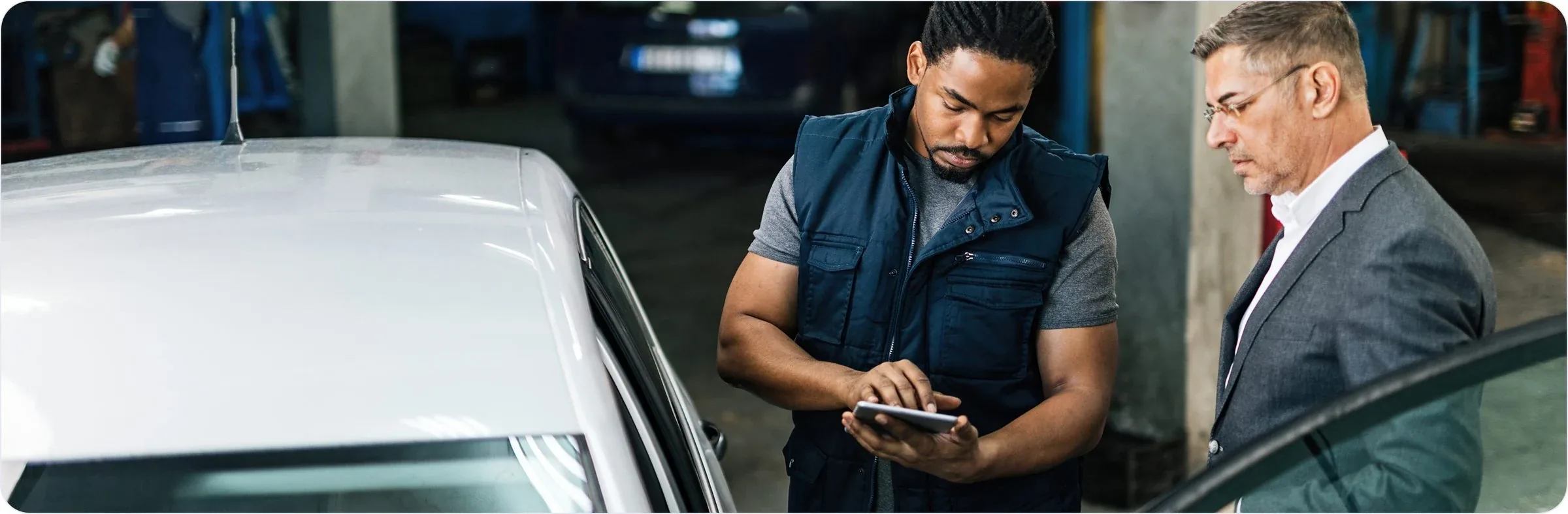 Technicien et gestionnaire consultant une tablette dans un atelier de concession